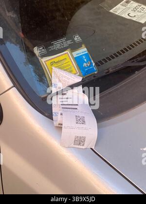 Cremona, Italia - 5 aprile 2025 la berlina argentata esposta con i biglietti di parcheggio rivela la presenza del veicolo parcheggiato a lato della strada in un cit Foto Stock