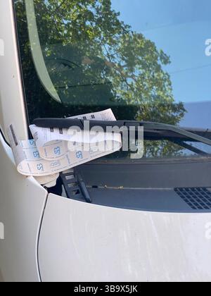 Cremona, Italia - 5 aprile 2025 la berlina argentata esposta con i biglietti di parcheggio rivela la presenza del veicolo parcheggiato a lato della strada in un cit Foto Stock