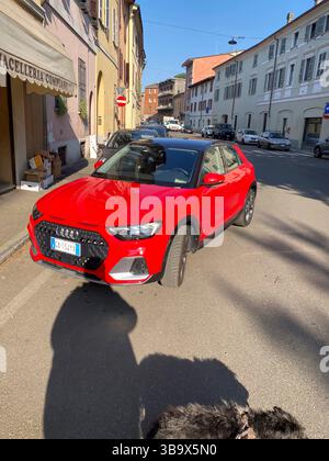 Cremona, Italia - 5 aprile 2025 Un 5 aprile 2023 Hatchback Fiery Red scivola attraverso le soleggiate strade europee catturando l'essenza dell'eleganza automobilistica con i suoi Foto Stock