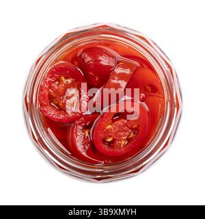 Fette di jalapeno rosso sottaceto, in un vaso di vetro aperto con tappo a vite, isolato, dall'alto. Peperoncini rossi di taglia media, tagliati a sezioni incrociate. Foto Stock