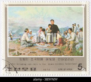 COREA DEL NORD, RPDC - 1976 ottobre 10: Francobollo multicolore 5 chon raffigurante il ritratto di Kim il Sung con contadini in collina. Attività rivoluzionarie di Kim il Sung, anniversario della rivoluzione. Visita al Tosongrang. 5ch, con contadini in collina. 10ch, con ragazzo e uomo in riva al mare. 15ch, dando casa alla mano della fattoria. 25ch, sulla strada fangosa davanti, con autista e ragazza. 40ch, camminando sotto la pioggia con ombrello. 50ch, osservando il ragazzo disegnare l'immagine a bordo strada Foto Stock