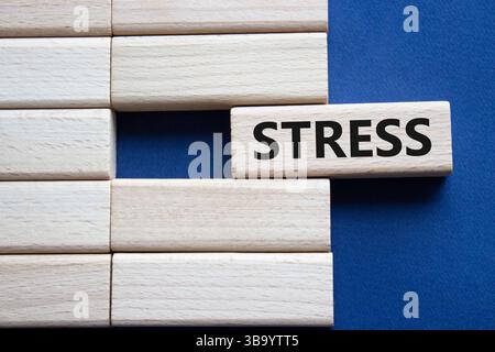 Simbolo di sollecitazione. Parola concettuale stress su blocchi di legno. Splendido sfondo blu intenso. Medicina e stress. Copia spazio. Foto Stock
