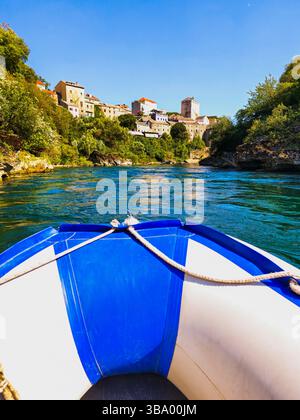 Giro in barca attraverso Neretva con una splendida vista della città vecchia di Mostar. Le attrazioni turistiche più popolari in Bosnia ed Erzegovina. Foto Stock
