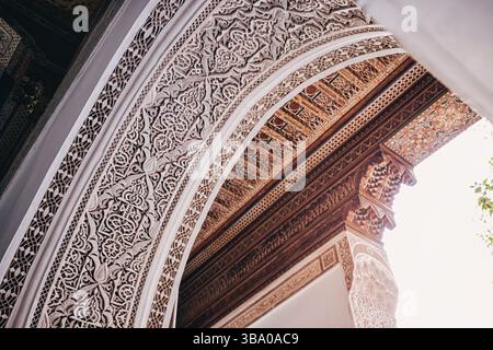 Dettagli architettonici di un arco marocchino splendidamente decorato e soffitto con intricati motivi floreali che mostrano l'artigianato tradizionale Foto Stock