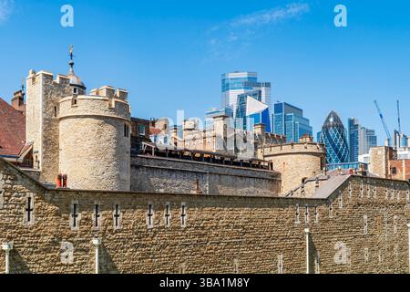 LONDRA, Regno Unito - 11 MAGGIO 2025: I moderni grattacieli della City di Londra creano uno sfondo architettonico contrastante alla storica Torre di Londra. Foto Stock