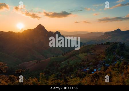 Il bellissimo paesaggio del tramonto risplende su un villaggio locale tribale sulla montagna nella valle del punto panoramico di Gigokor, Pang Mapha, Mae Hong Son, Thailandia Foto Stock