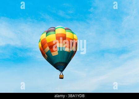 Vivace pallone aerostatico colorato che galleggia nel cielo blu al festival del parco a tema Foto Stock