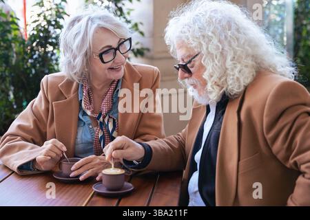 Coppia caucasica senior che parla da vicino mentre beve un caffè al caffè all'aperto Foto Stock