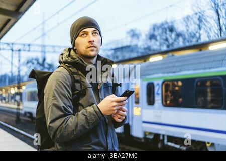 Sopot Stazione ferroviaria urbana veloce. Giovane uomo in piedi e in attesa di treno sulla piattaforma. Viaggi turistici in treno. Ritratto Di Maschio Caucasico In Ferrovia Tr Foto Stock