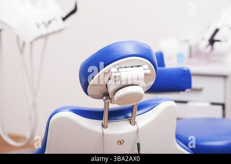 Sedia dentale professionale blu con focalizzazione sul lato posteriore del poggiatesta Foto Stock