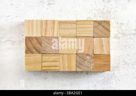 Foto piatta, quindici cubi di legno disposti in griglia 3 x 5, su un pannello di lavoro bianco. Aggiungi il tuo testo a quadrati di legno vuoti, Liptovsky Hradok, Slovacchia, Foto Stock