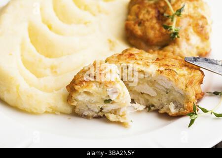 Cotolette di pollo e purè di patate in una piastra da vicino Foto Stock
