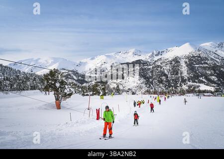 People, adults and kids, skiers and snowboarders going up on drag lift. Ski winter holidays in Andorra, El Tarter, Pyrenees Mountains, Grandvalira Foto Stock