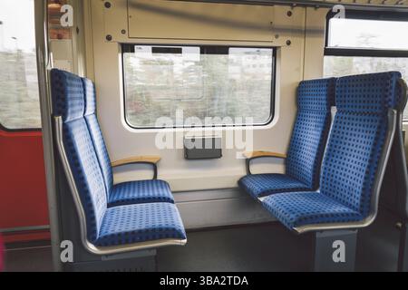 All'interno della Wagon Train Germany, Dusseldorf. Interno del treno vuoto. Vista interna del corridoio interno dei treni passeggeri con sedili in tessuto blu in tedesco Foto Stock