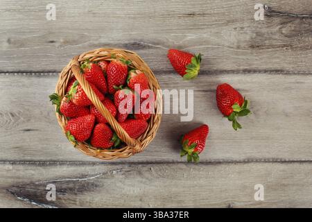 Vista del tavolo su un cestino pieno di fragole su una scrivania in legno Foto Stock