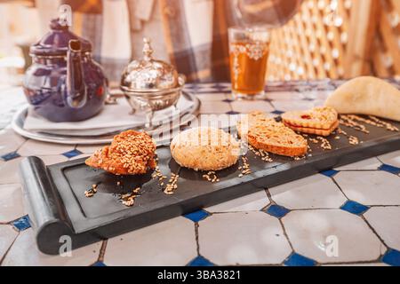 Selezione di dolci marocchini tradizionali serviti con tè alla menta in un riad a Marrakech, Marocco Foto Stock