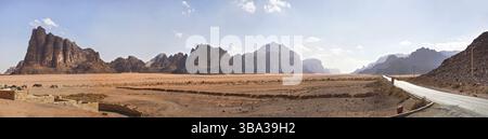 Sette pilastri di saggezza visti all'ingresso dell'area protetta di Wadi Rum dal centro visitatori. Piccoli veicoli fuoristrada parcheggiati in primo piano, Wadi Rum, Jo Foto Stock