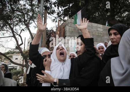 Parenti palestinesi e amici di Hikmat Abdul Nabi, 34 anni, piangono e piangono durante il suo funerale nel villaggio di Askar al-Balad, a est di Nablus, in Cisgiordania. Hikmat è stato ucciso durante un'operazione militare israeliana nel quartiere di Masaken al-Shaabiya vicino a Nablus, in Cisgiordania, dopo che un drone dell'aeronautica israeliana gli ha sparato un missile. Foto Stock