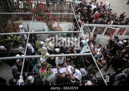 Palestinesi e parenti di Hikmat Abdul Nabi, 34 anni, salutarono il suo corpo durante il suo funerale nel villaggio di Askar al-Balad, a est di Nablus, in Cisgiordania. Hikmat è stato ucciso durante un'operazione militare israeliana nel quartiere di Masaken al-Shaabiya vicino a Nablus, in Cisgiordania, dopo che un drone dell'aeronautica israeliana gli ha sparato un missile. Foto Stock