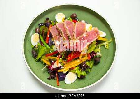 tradizionale insalata nicoise di tonno con patate, olive, fagioli, uova e lattuga con sfondo bianco Foto Stock