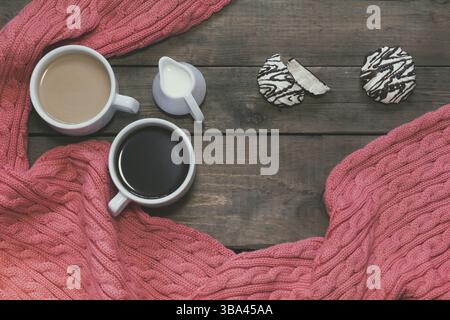 Tazza di caffè nero, una tazza di caffè con il latte, la crema di latte. Tessuto rosa sciarpa. Marshmallow con il cioccolato. Legno scuro dello sfondo. Bellissimo caffè vintage gr Foto Stock