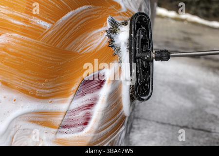 Dettagli sulla spazzola lasciando tratti in sapone e schiuma di un autolavaggio giallo Foto Stock