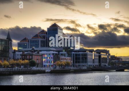 Dublino, Irlanda, 10 ottobre 2020 Neon illuminato, simile a una piramide, architettura di un edificio George Quay Plaza al tramonto, situato vicino al fiume Liffey, E. Foto Stock