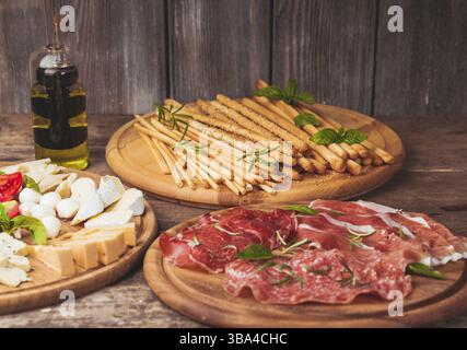 Antipasto Italiano - vari tipi di prosciutto, formaggio e grissini Foto Stock