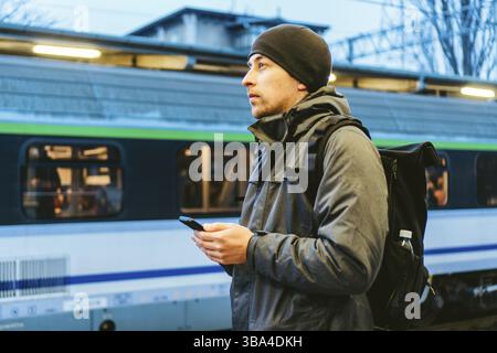 Sopot Stazione ferroviaria urbana veloce. Giovane uomo in piedi e in attesa di treno sulla piattaforma. Viaggi turistici in treno. Ritratto Di Maschio Caucasico In Ferrovia Tr Foto Stock