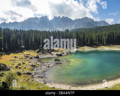 Il Karersee sotto il passo del Karersee ai piedi del massiccio del Latemar in alto Adige, Italia, Europa Foto Stock