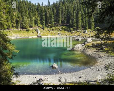 Il Karersee sotto il passo del Karersee ai piedi del massiccio del Latemar in alto Adige, Italia, Europa Foto Stock