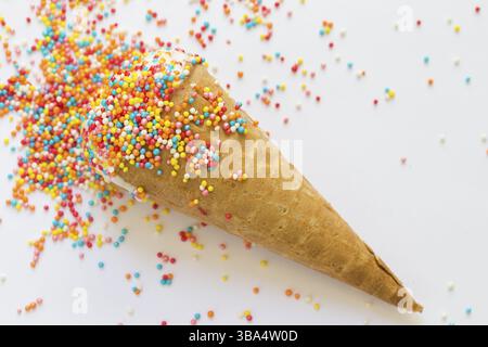 Il gelato in un cono di cialda ricoperta con un luminoso spolverata di close-up Foto Stock