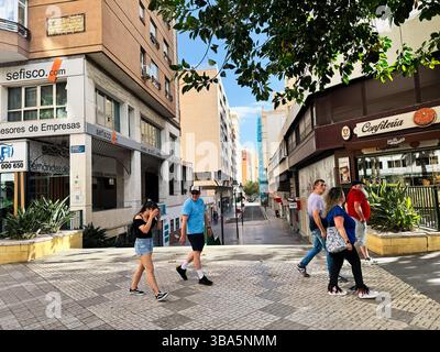 Malaga, Spagna - 2 maggio 2025: Una vivace scena di strada a Malaga con pedoni che camminano tra i vari edifici urbani. Foto Stock