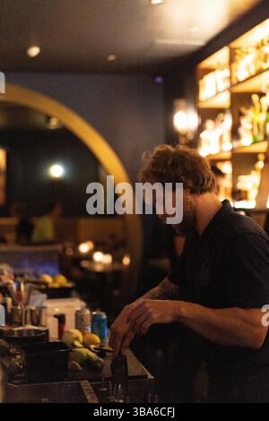 Il barman prepara cocktail in un bar notturno Foto Stock