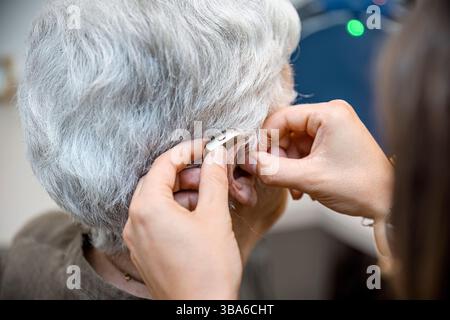 Un audioprotesista è un professionista della salute dell'udito che vende, adatta, regola e sostituisce gli apparecchi acustici sulla base di un certificato scritto da un orecchio, no Foto Stock