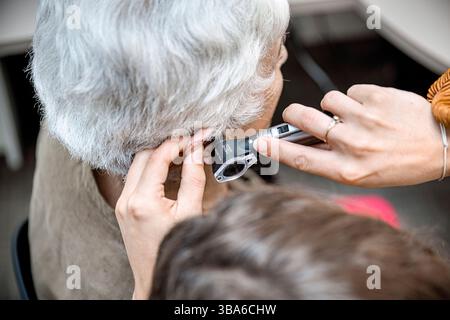Un audioprotesista è un professionista della salute dell'udito che vende, adatta, regola e sostituisce gli apparecchi acustici sulla base di un certificato scritto da un orecchio, no Foto Stock