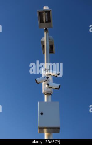 Primo piano delle telecamere di sicurezza esterne e luci a LED con cielo blu - giorno Foto Stock