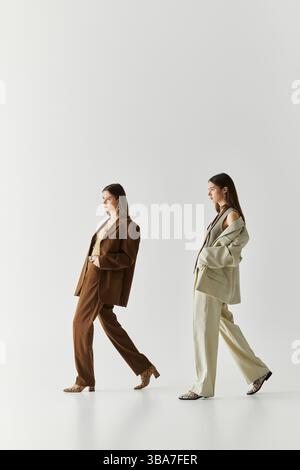 Due bellissime gemelle mostrano il loro stile unico mentre si legano con un abbigliamento elegante. Foto Stock