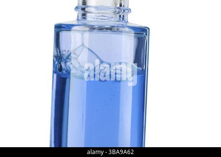 Parte di un flacone con primo piano di liquido cosmetico blu su sfondo bianco Foto Stock