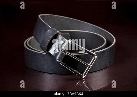 Cintura in pelle nera su sfondo scuro. Prodotti in pelle Foto Stock