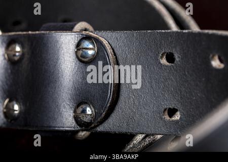 Cintura in pelle nera su sfondo scuro. Prodotti in pelle Foto Stock