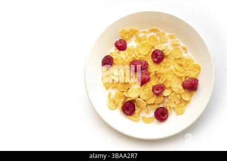 Fiocchi di mais nel latte con lamponi su un piatto bianco Foto Stock
