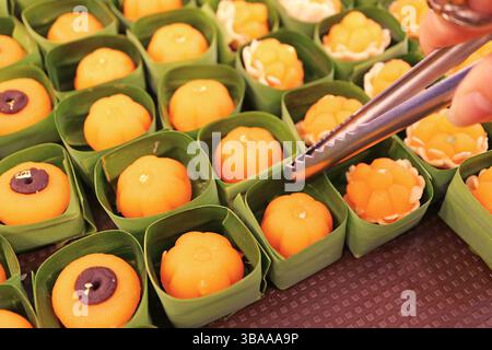 File di dessert tailandese assortiti di buon auspicio a base di tuorli d'uovo zuccherati, mescolati con farina di frumento bollente e latte di cocco Foto Stock