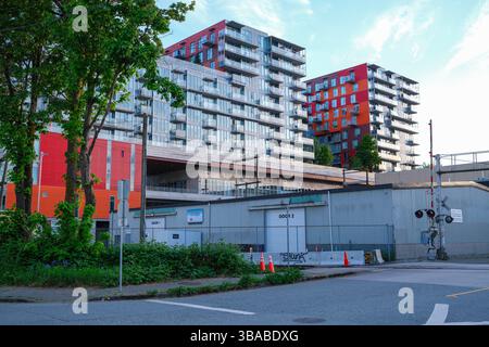 Il complesso condominiale Strathcona Village attraversato i binari ferroviari di East Vancouver, British Columbia. Foto Stock