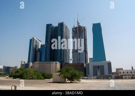 Un moderno skyline caratterizzato da numerosi alti edifici in costruzione e strutture completate. La scena è ambientata contro un cielo azzurro, con una Foto Stock