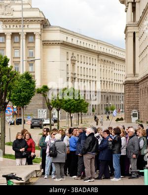 Gruppo di turisti in un tour panoramico guidato a Piazza Nezavisimost a Sofia, in Bulgaria, vicino al Consiglio dei Ministri e all'ufficio presidenziale bui Foto Stock