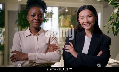 Donne d'affari fiduciose partner commerciali donne multirazziali colleghi africani asiatici ragazze americane cinesi dipendenti professionali collaboratori mani Foto Stock