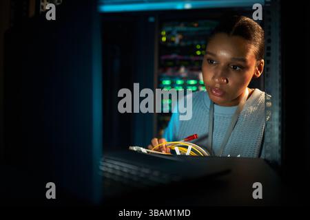 Donna che lavora su un server nel data center Foto Stock