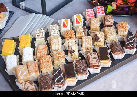 Candy bar con diversi tipi di dolci e pasticcini. Dolci torte su un piatto. Molta varietà di praline al cioccolato Foto Stock