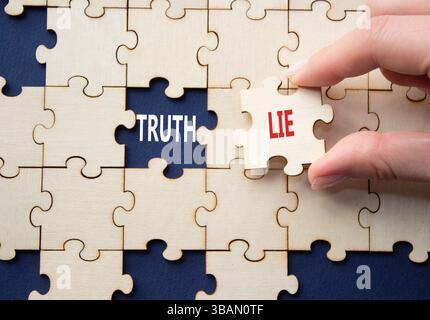 Simbolo della verità o della menzogna. Concetto parola verità o bugia su puzzle di legno. Mano d'affari. Splendido sfondo blu intenso. Business and Truth or Lie Concept. Foto Stock